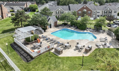 a swimming pool with chairs next to a building