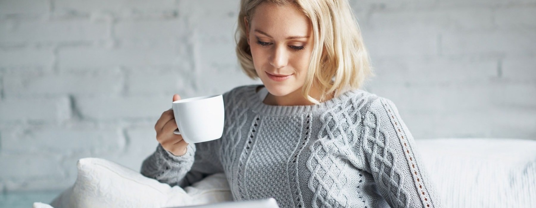 a woman holding a drink and reading